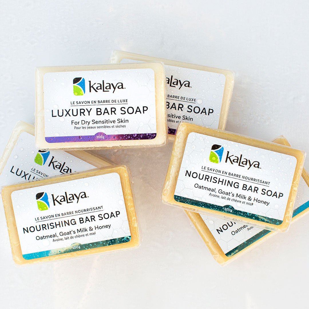 Piled collection of bars of soap, including Kalaya Luxury Bar Soap and Kalaya Nourishing Bar Soap